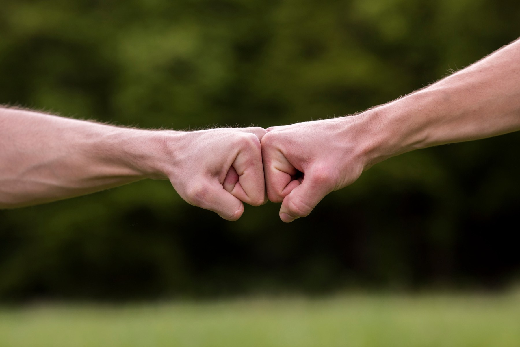 Twee handen die elkaar ondersteunen met een vuistgroet